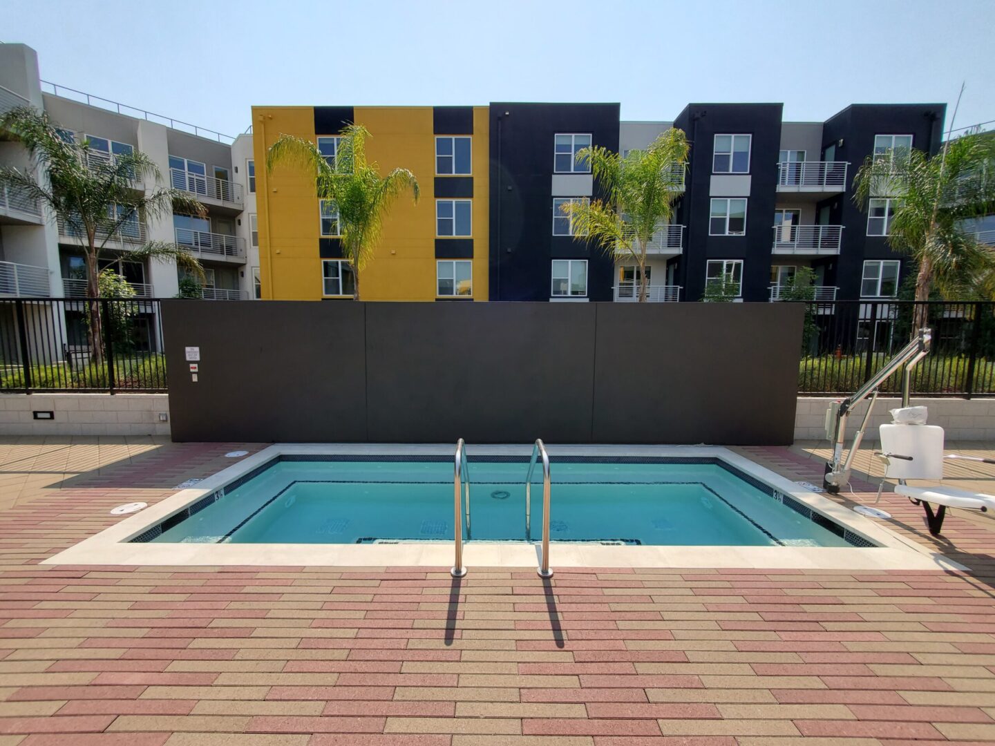 A pool with a yellow and black wall in the background