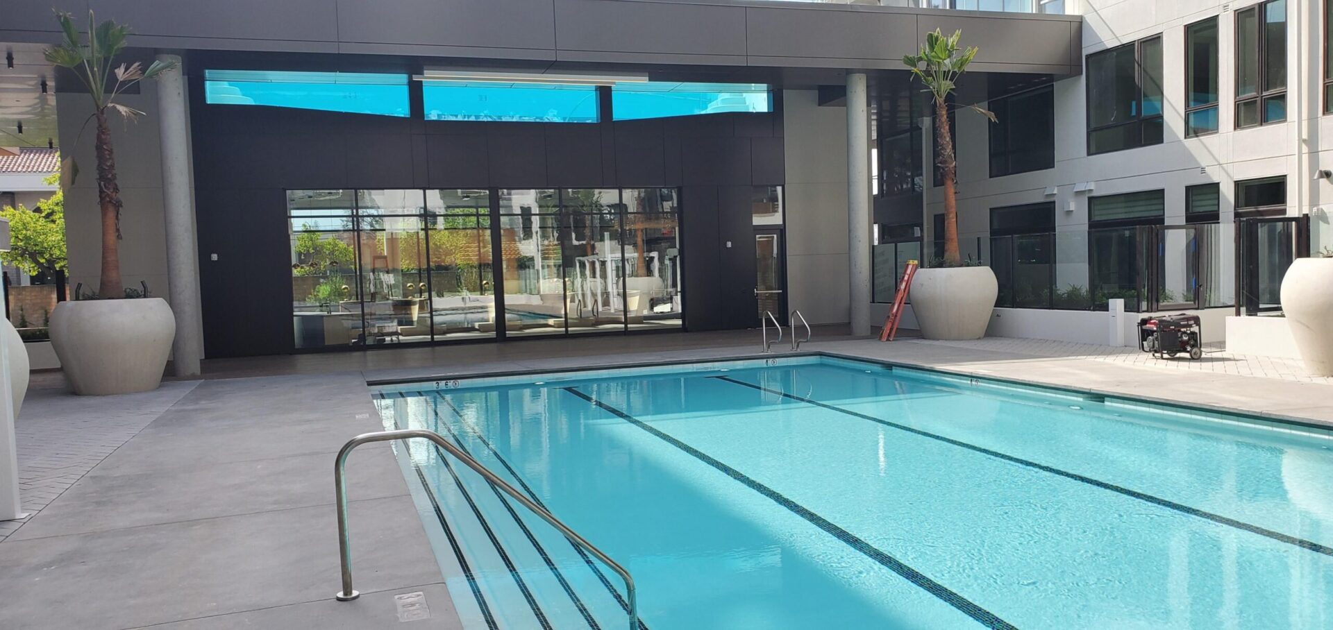 A pool with a large window in the background.