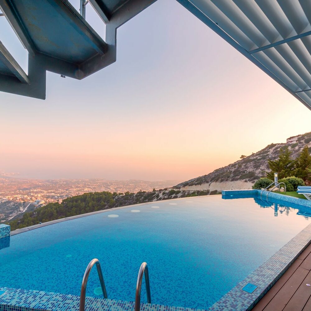 A pool with an ocean view and a deck.